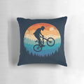 Vintage-inspired mountain biking pillow featuring a cyclist jumping over a sunset landscape