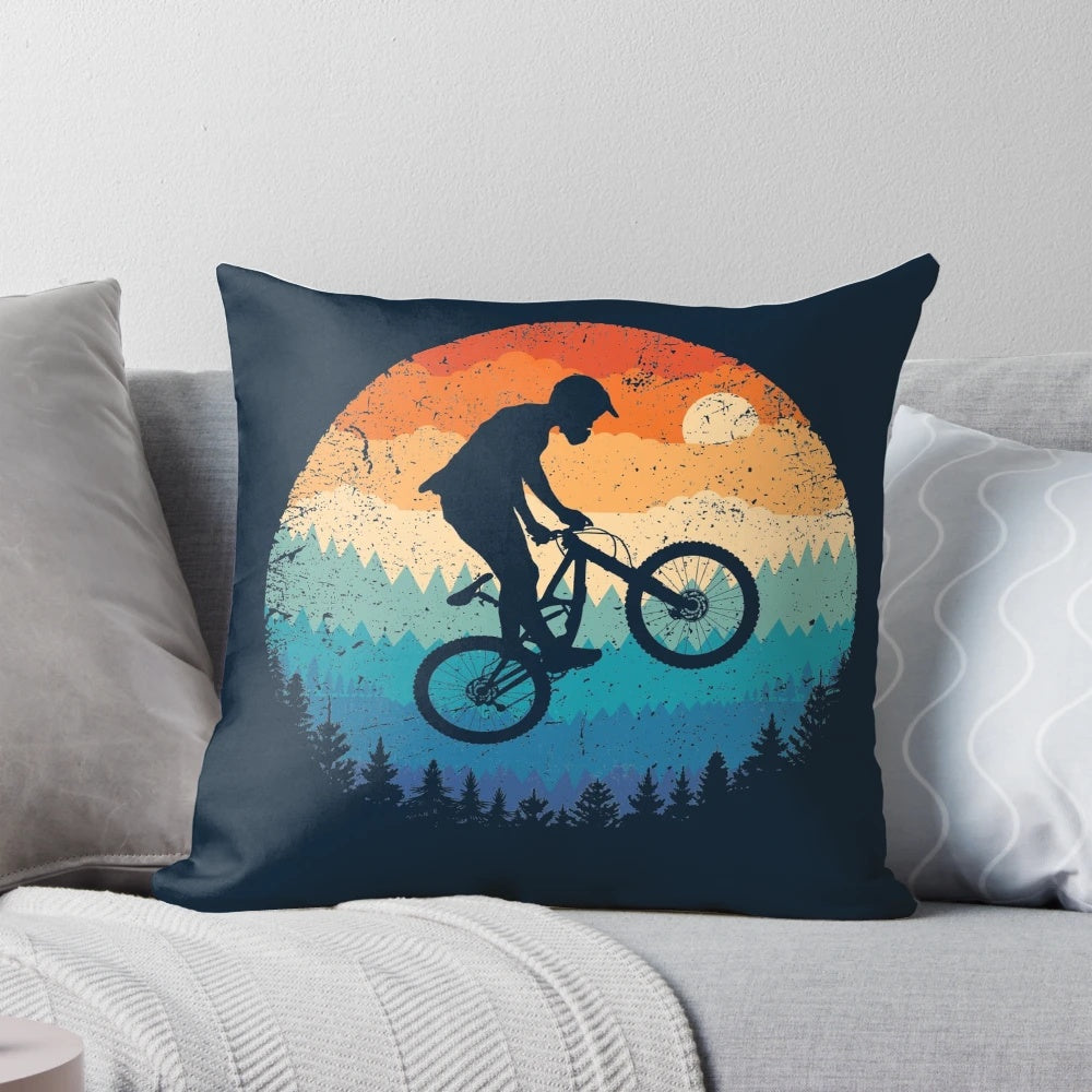 Vintage-inspired mountain biking pillow featuring a cyclist jumping over a sunset landscape