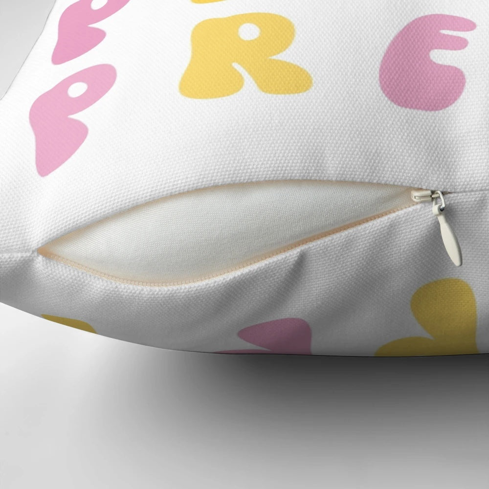 Vibrant yellow and pink preppy smiley face pillow with wavy retro text