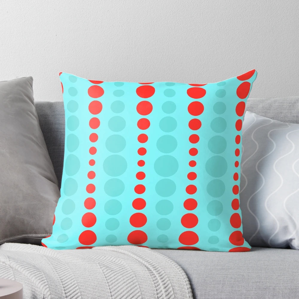 Closeup of a retro-styled throw pillow in a turquoise and red polka dot pattern, representing 1960s mid-century modern design.