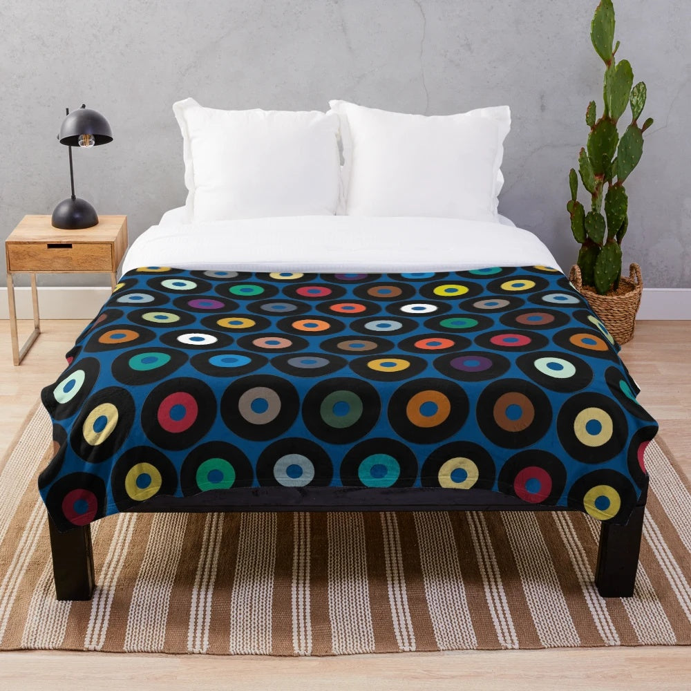 Blue plush blanket with retro vinyl record-inspired polka dot pattern and multicolor graphic design