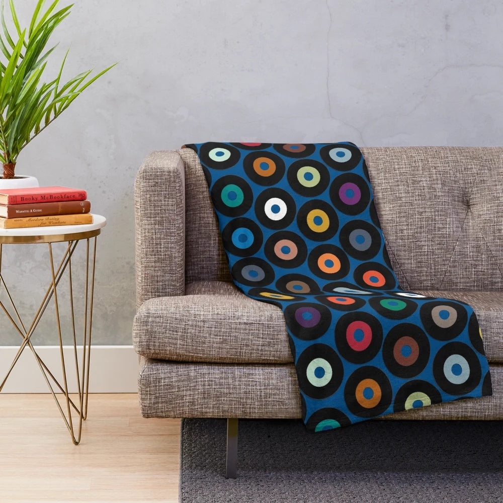 Blue plush blanket with retro vinyl record-inspired polka dot pattern and multicolor graphic design