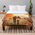 Couple embracing in front of historic Roman architecture with sunset in background on plush blanket