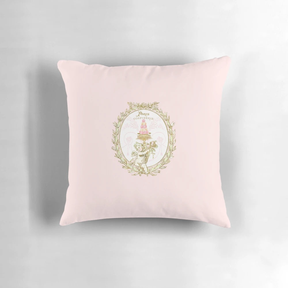 A vintage-inspired pillow featuring a French patisserie macaron label design in pastel pink and white colors.