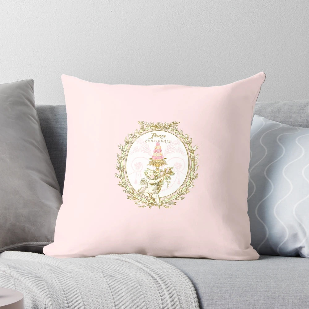 A vintage-inspired pillow featuring a French patisserie macaron label design in pastel pink and white colors.