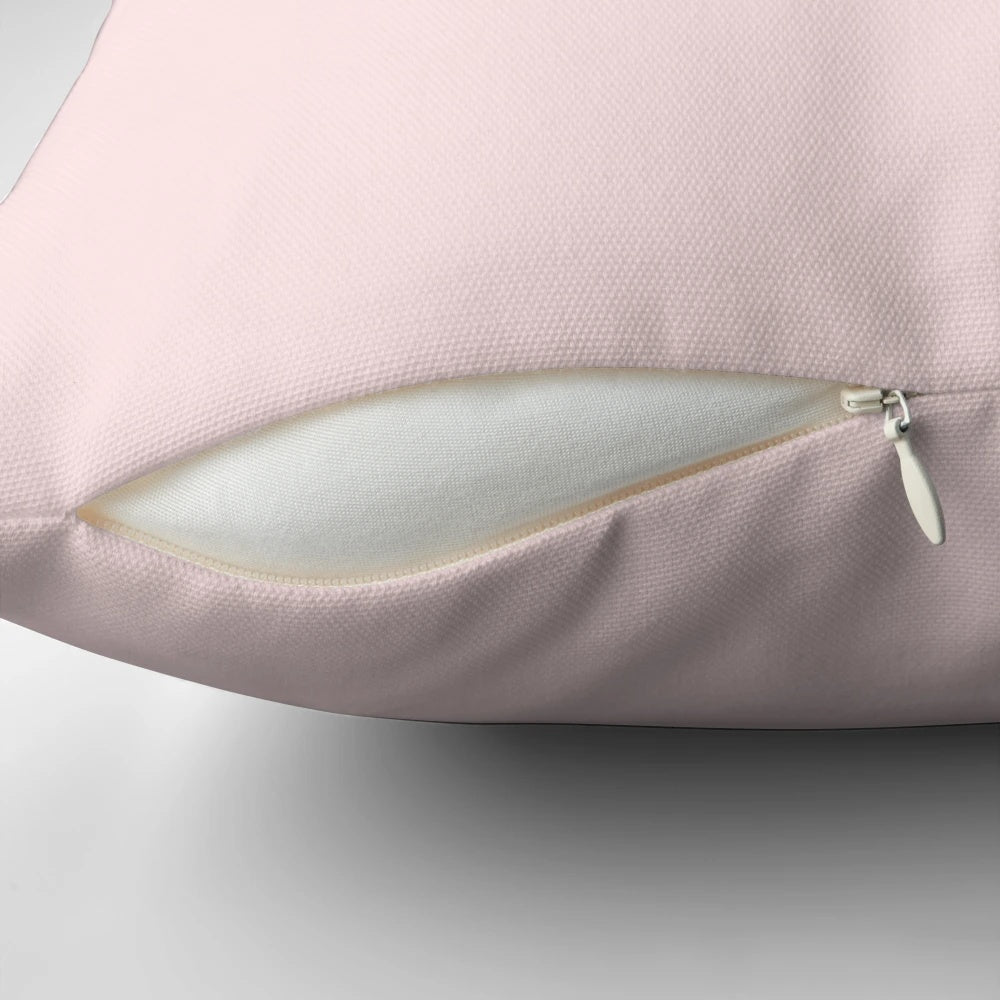 A vintage-inspired pillow featuring a French patisserie macaron label design in pastel pink and white colors.