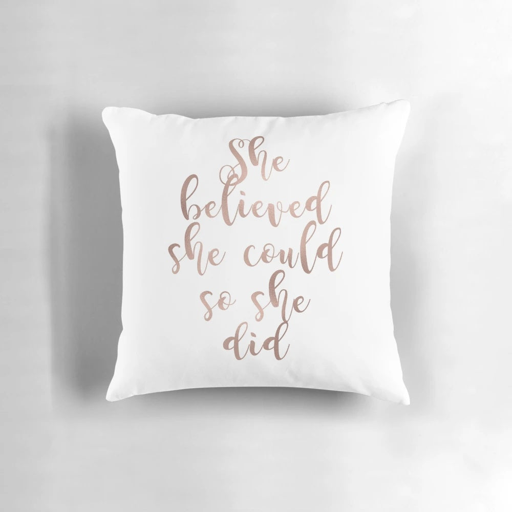 Rose gold foil-printed throw pillow with the motivational quote "She believed she could so she did"