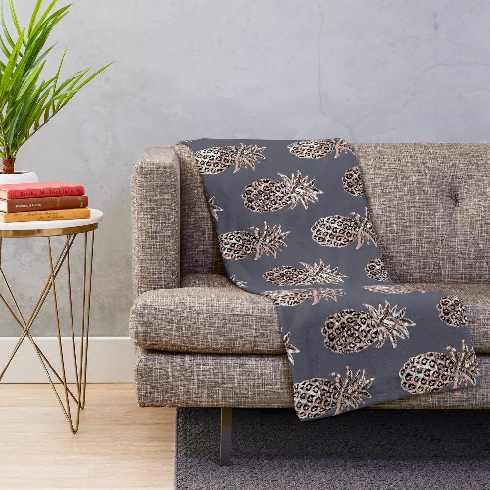 Rose gold pineapple design on a gray plush blanket