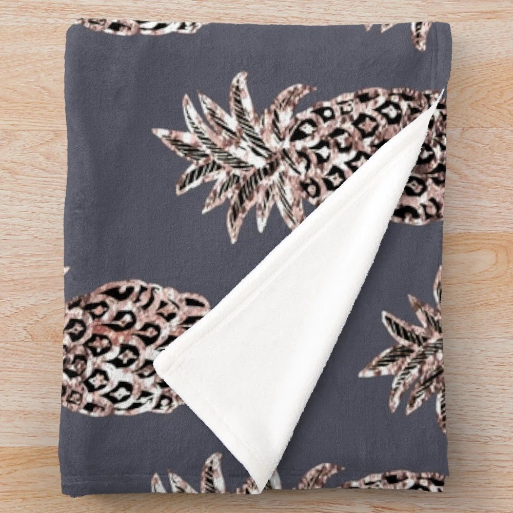 Rose gold pineapple design on a gray plush blanket