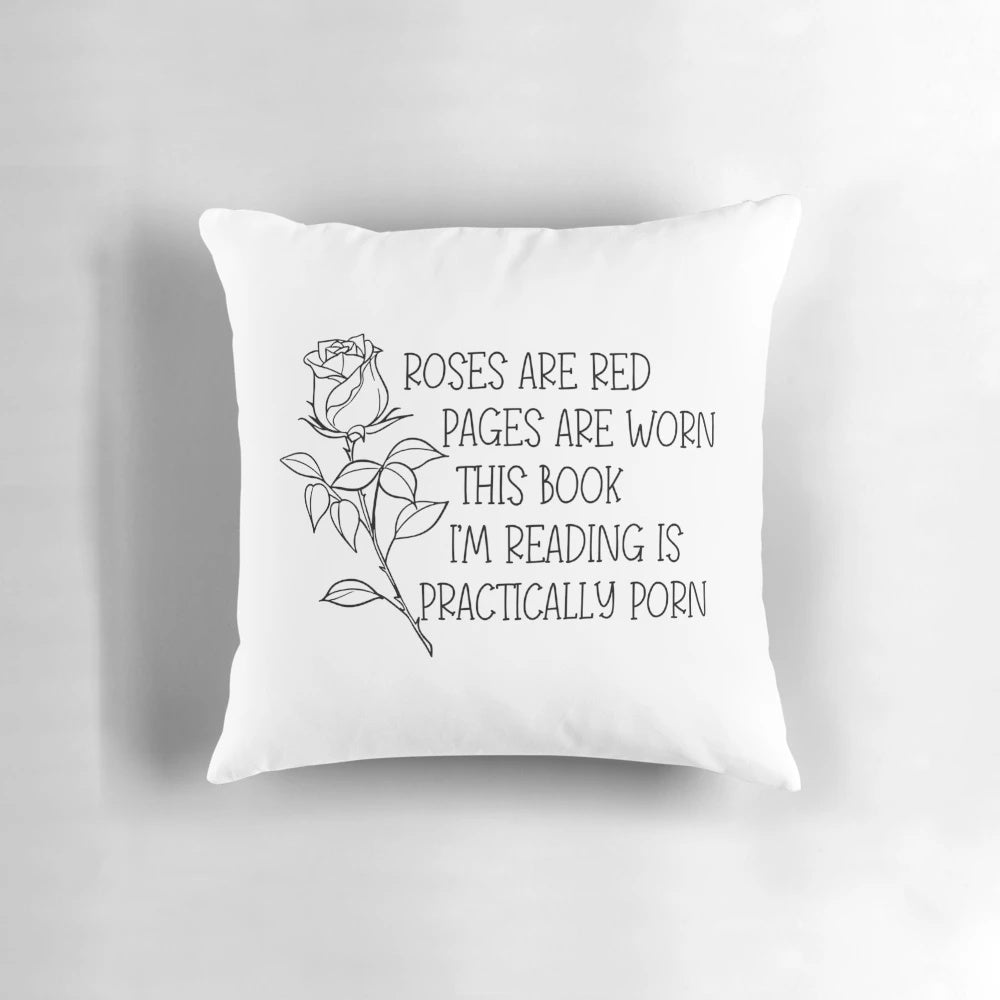 A black and white pillow with the text "Roses are red, pages are worn, the book I'm reading is practically porn.