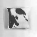 Rustic black and white cowhide pillow with natural cattle skin pattern