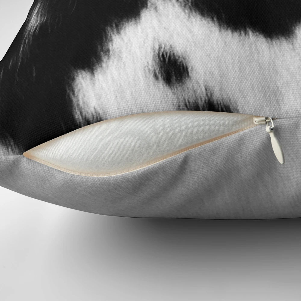 Rustic black and white cowhide pillow with natural cattle skin pattern