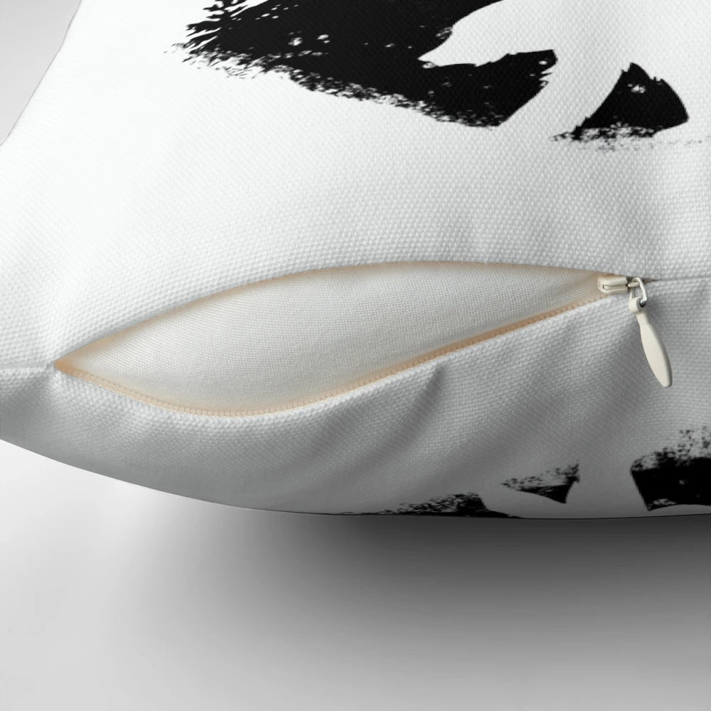 Black and white throw pillow featuring a bear paw print design against a forest landscape background.