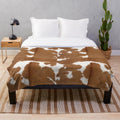 Brown cowhide plush blanket with cow print pattern