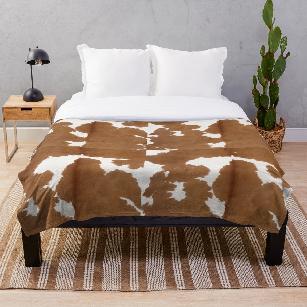 Brown cowhide plush blanket with cow print pattern