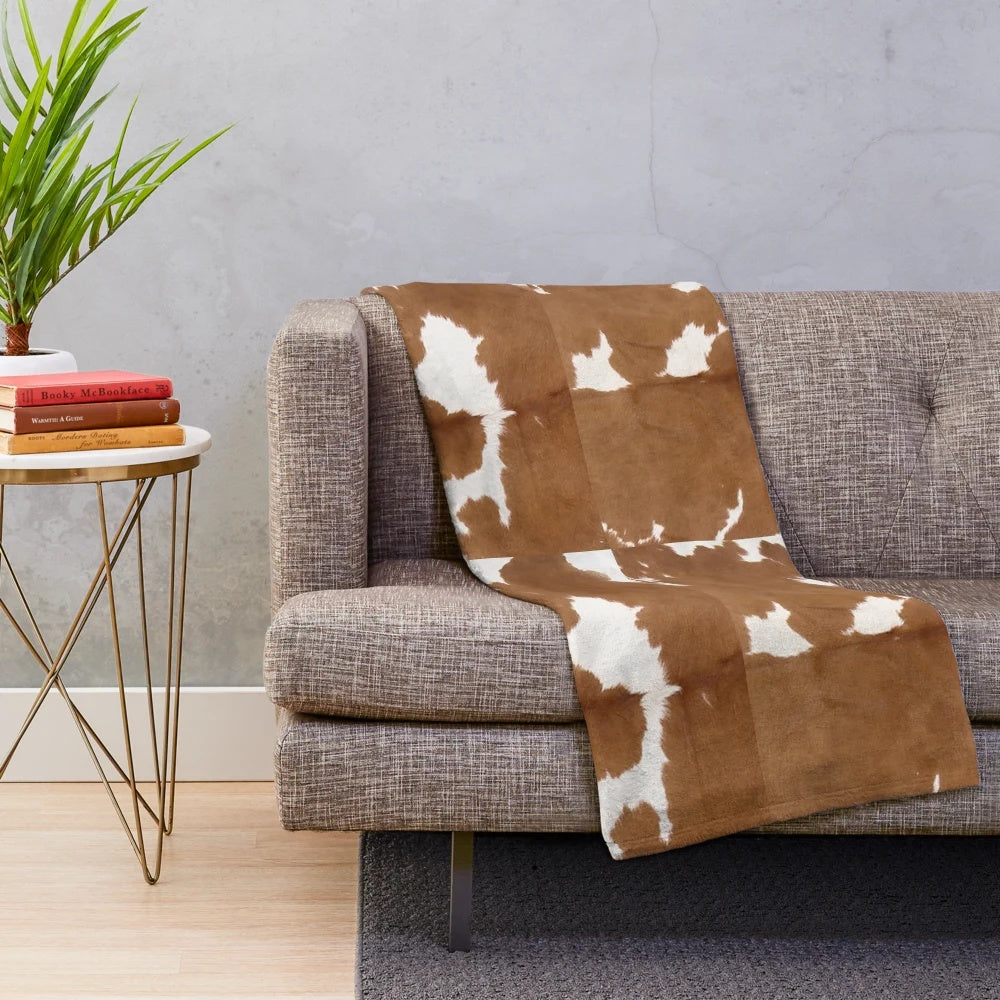 Brown cowhide plush blanket with cow print pattern