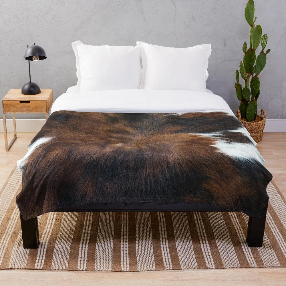 Soft, plush blanket with a realistic cow print design for a cozy, rustic home