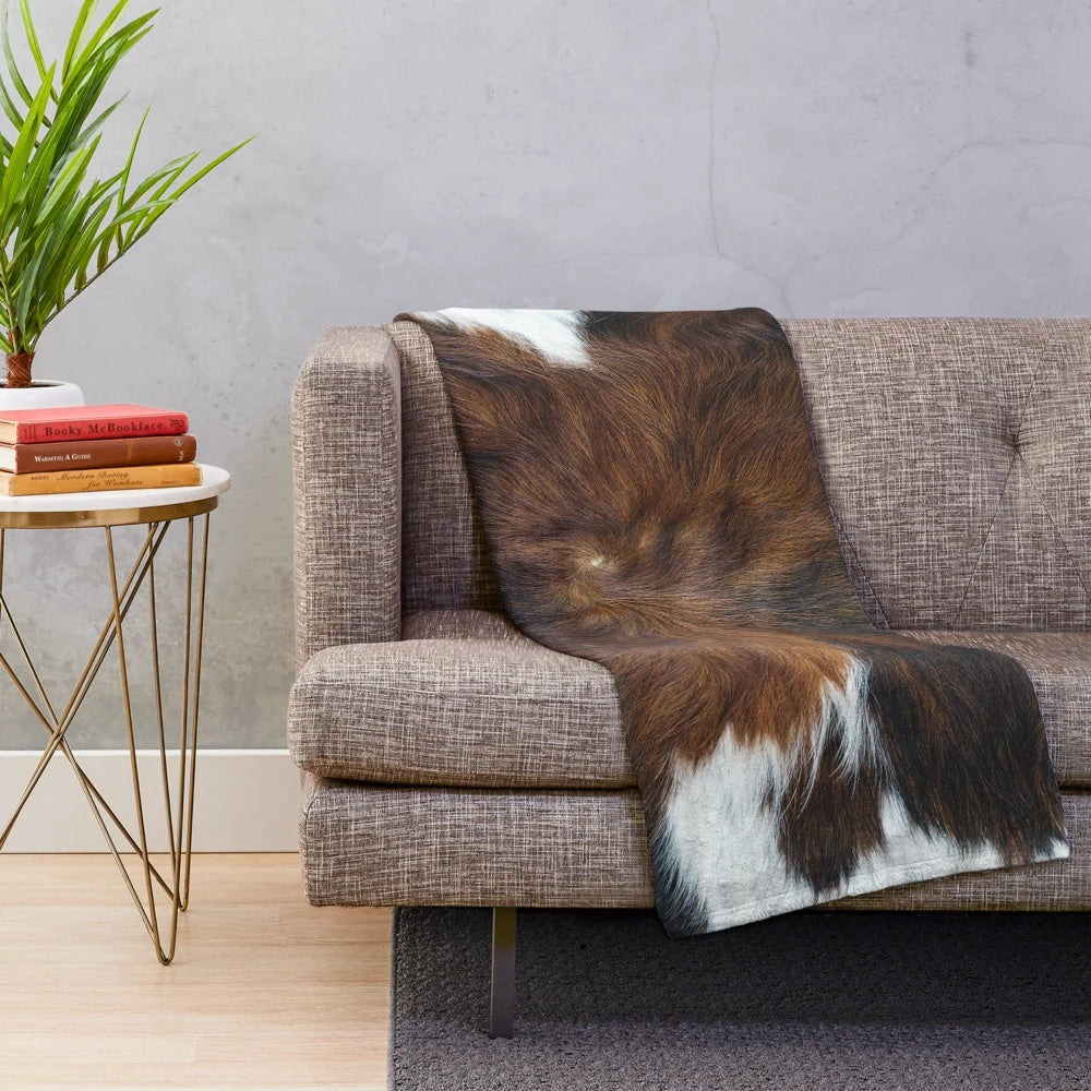 Soft, plush blanket with a realistic cow print design for a cozy, rustic home