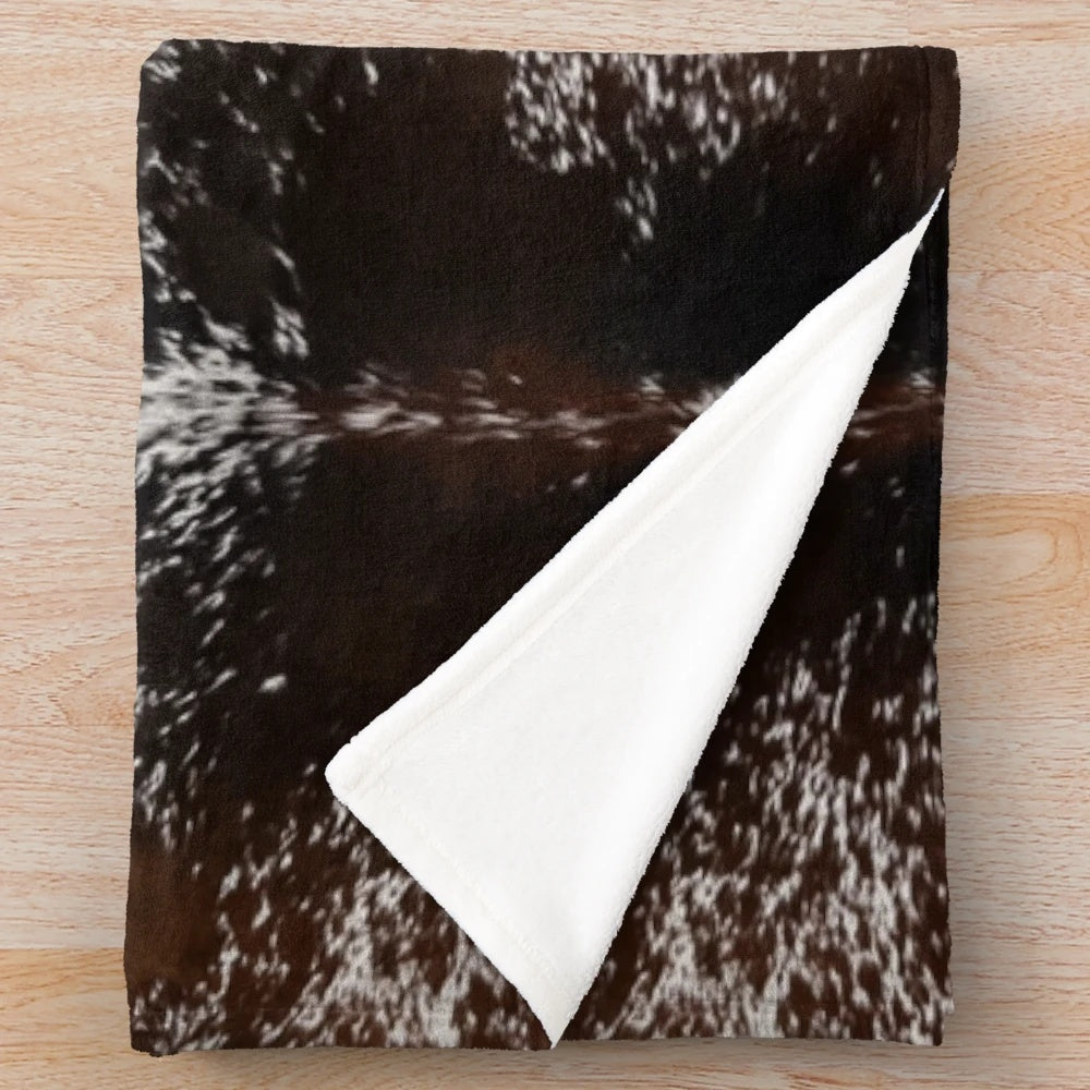 Cowhide-patterned plush blanket for rustic, farmhouse, or western-inspired home decor
