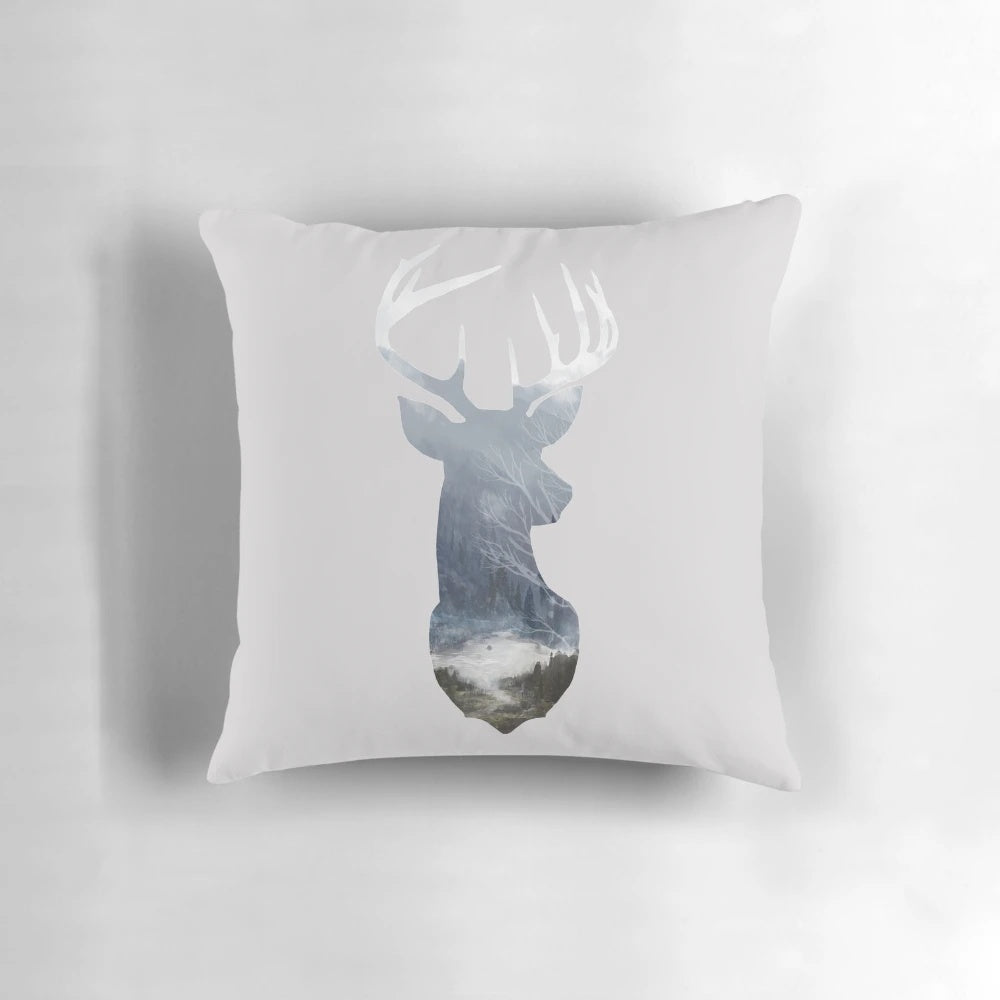A soft, decorative pillow featuring a serene deer silhouette in a misty forest landscape.