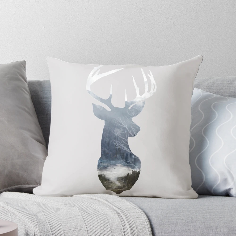 A soft, decorative pillow featuring a serene deer silhouette in a misty forest landscape.