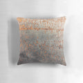 A rustic, distressed metal pillow with a textured, oxidized surface for an industrial-style home accent.