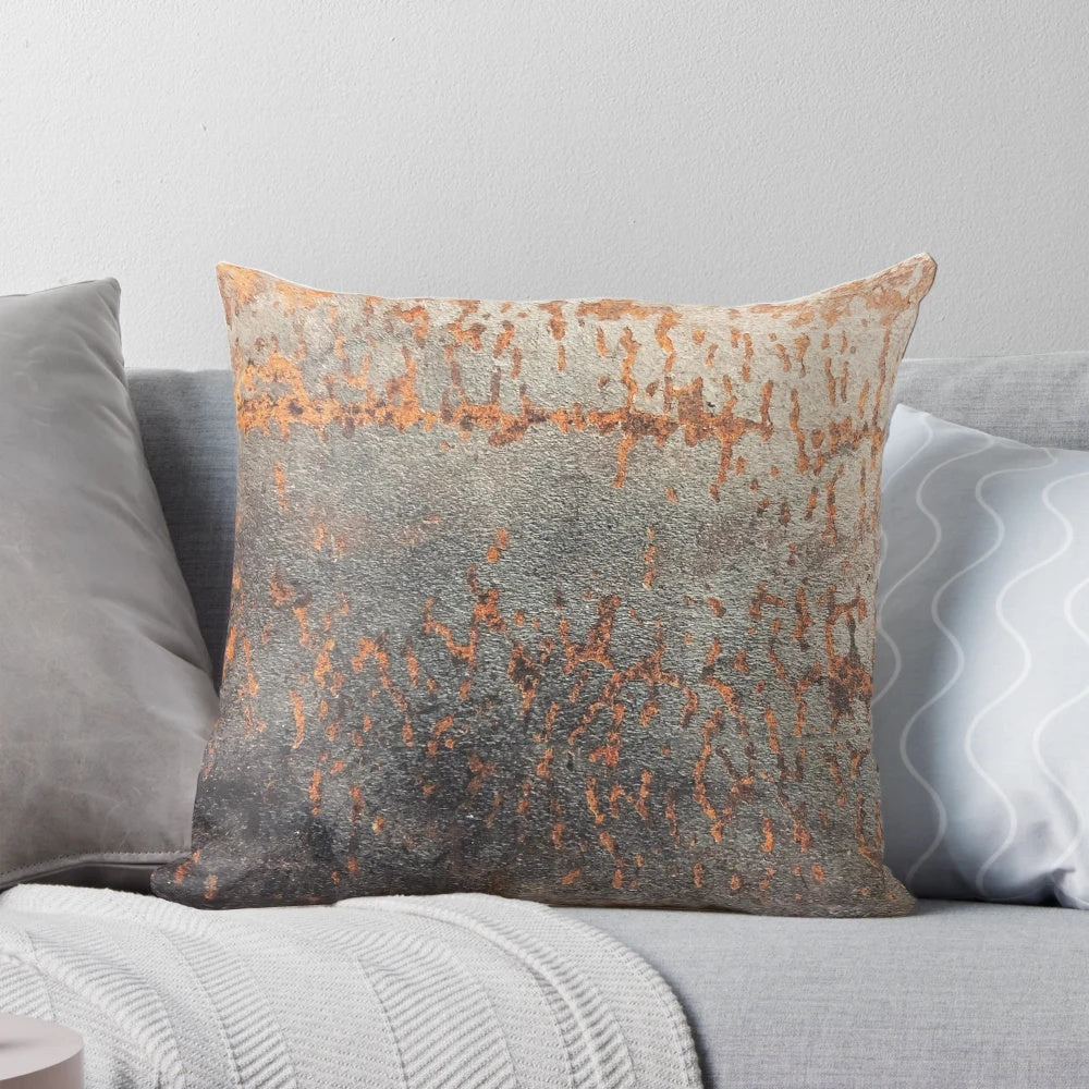 A rustic, distressed metal pillow with a textured, oxidized surface for an industrial-style home accent.