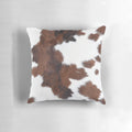 Decorative faux cow hide throw pillow with a brown and white cow print design