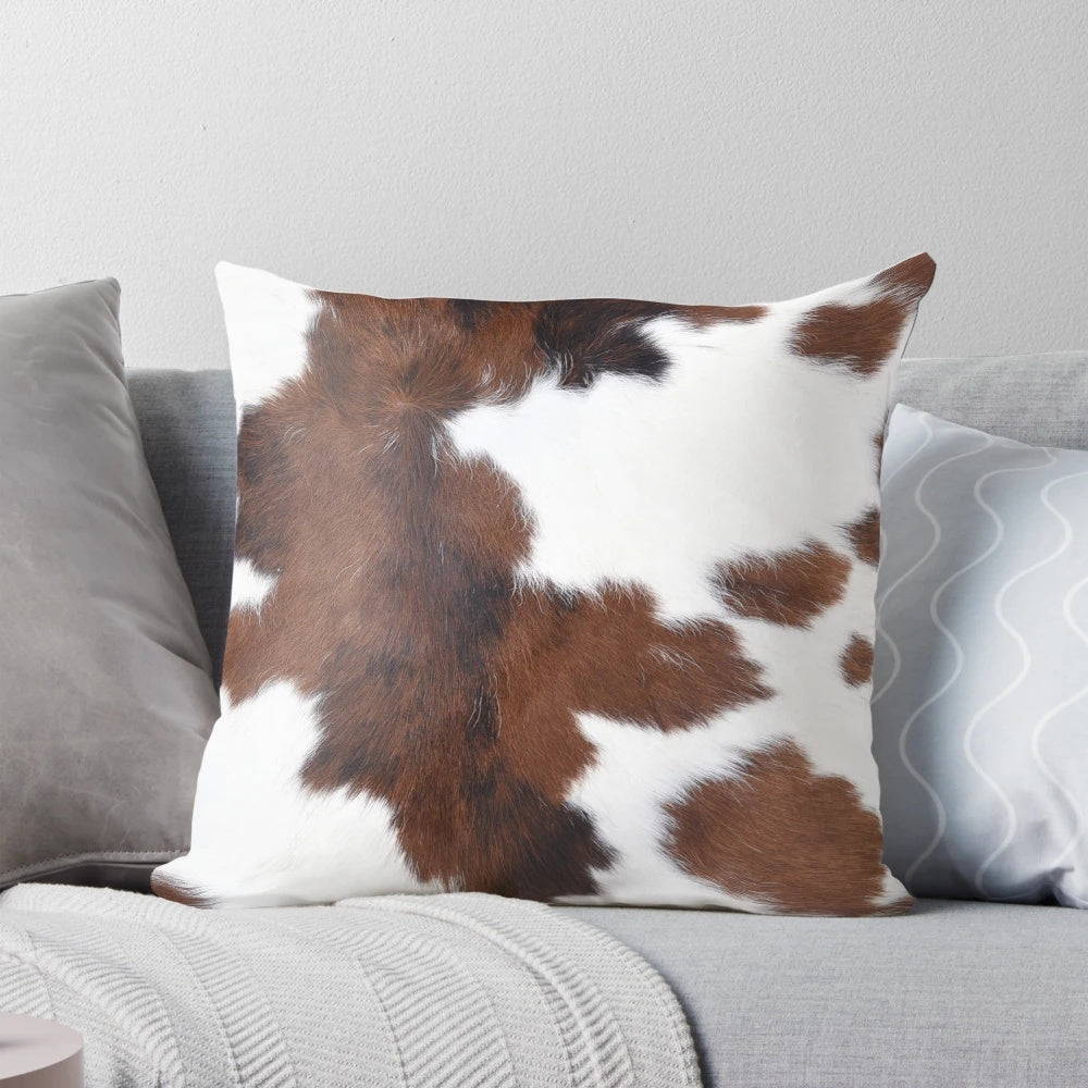 Decorative faux cow hide throw pillow with a brown and white cow print design