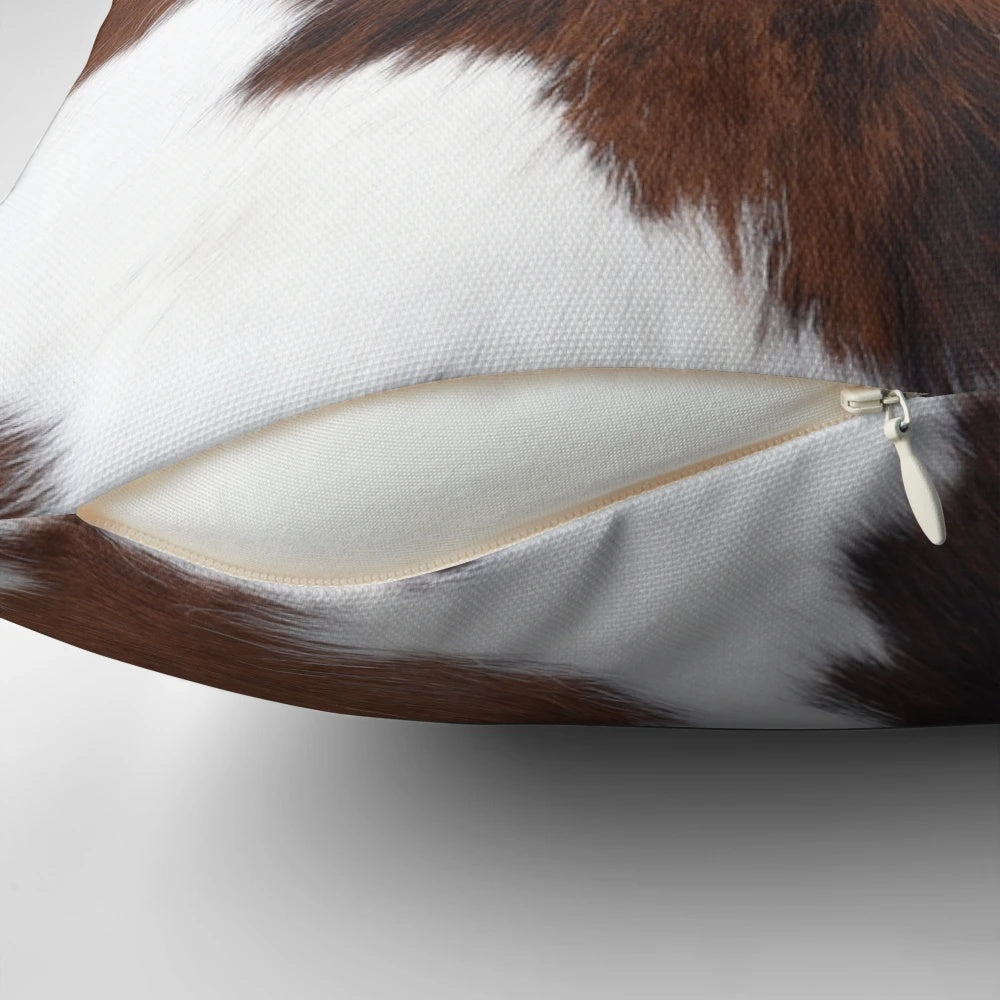 Decorative faux cow hide throw pillow with a brown and white cow print design