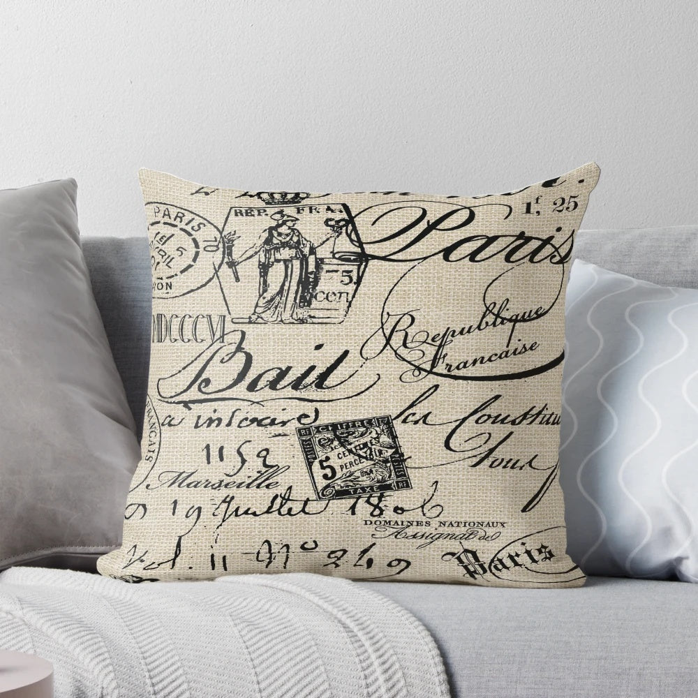 A neutral-colored decorative throw pillow with a handwritten French script design, perfect for adding a touch of vintage charm to any space.