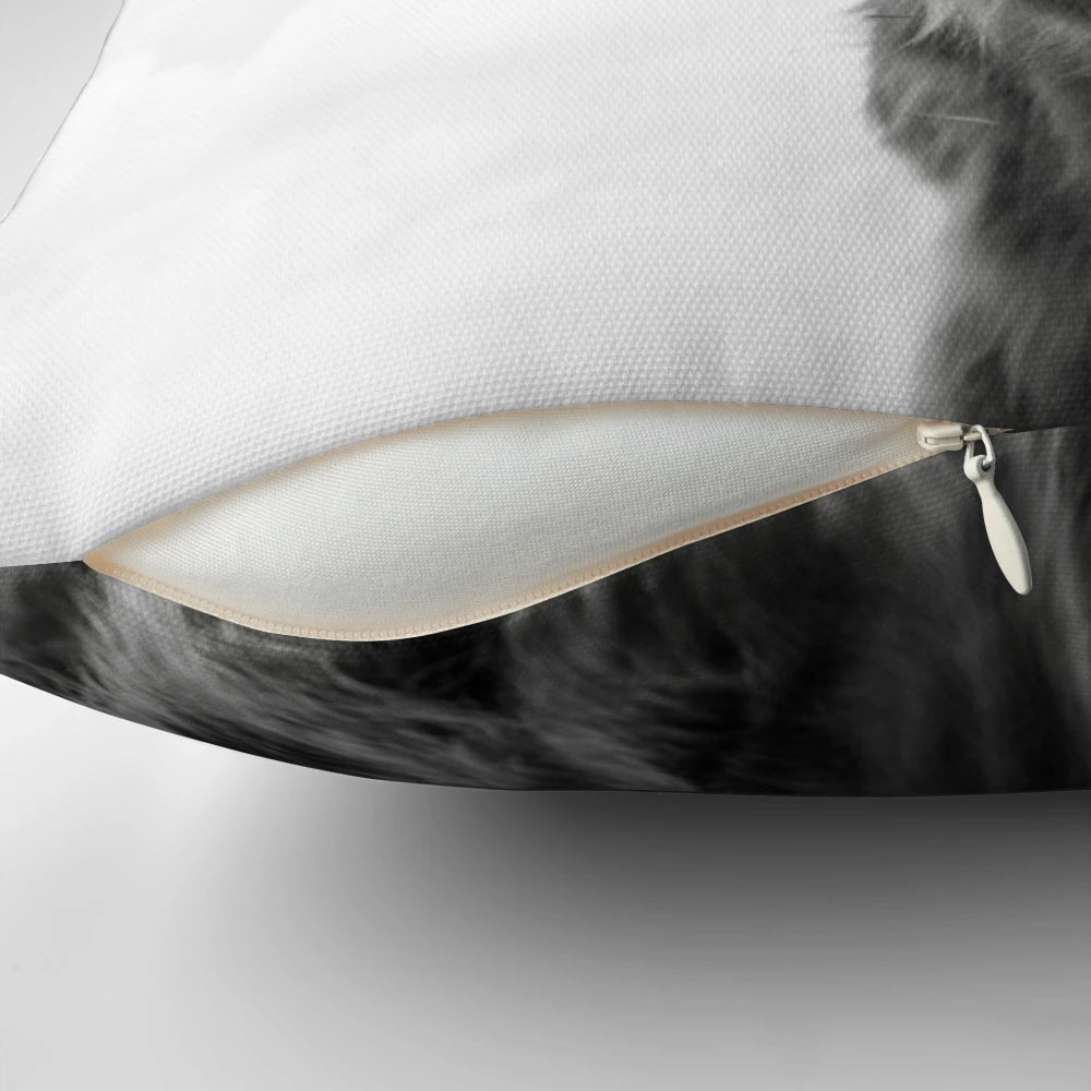 Black and white highland cow illustrated on a decorative farmhouse-style pillow