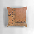Pillow featuring a distressed, rusty metal surface with riveted joints