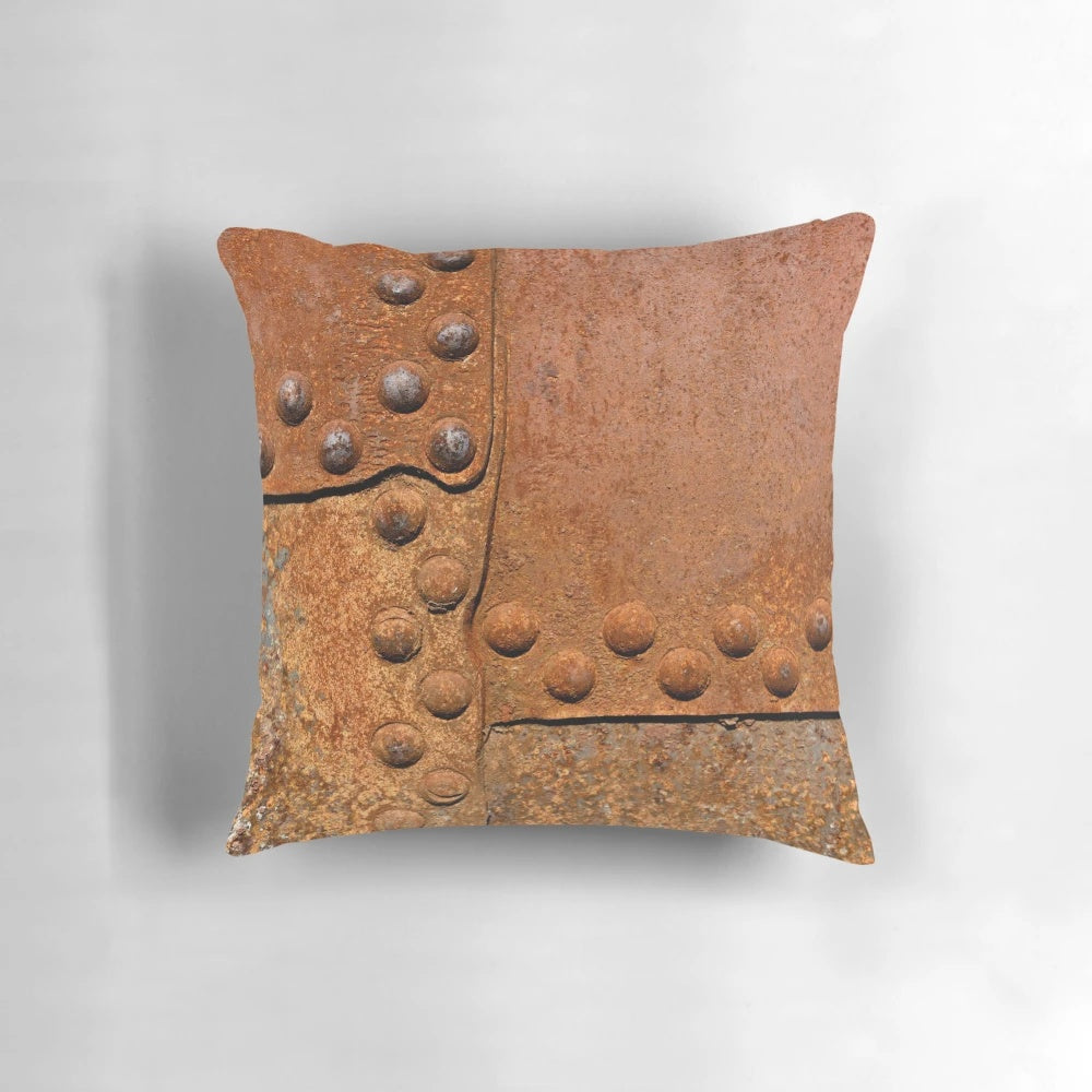 Pillow featuring a distressed, rusty metal surface with riveted joints