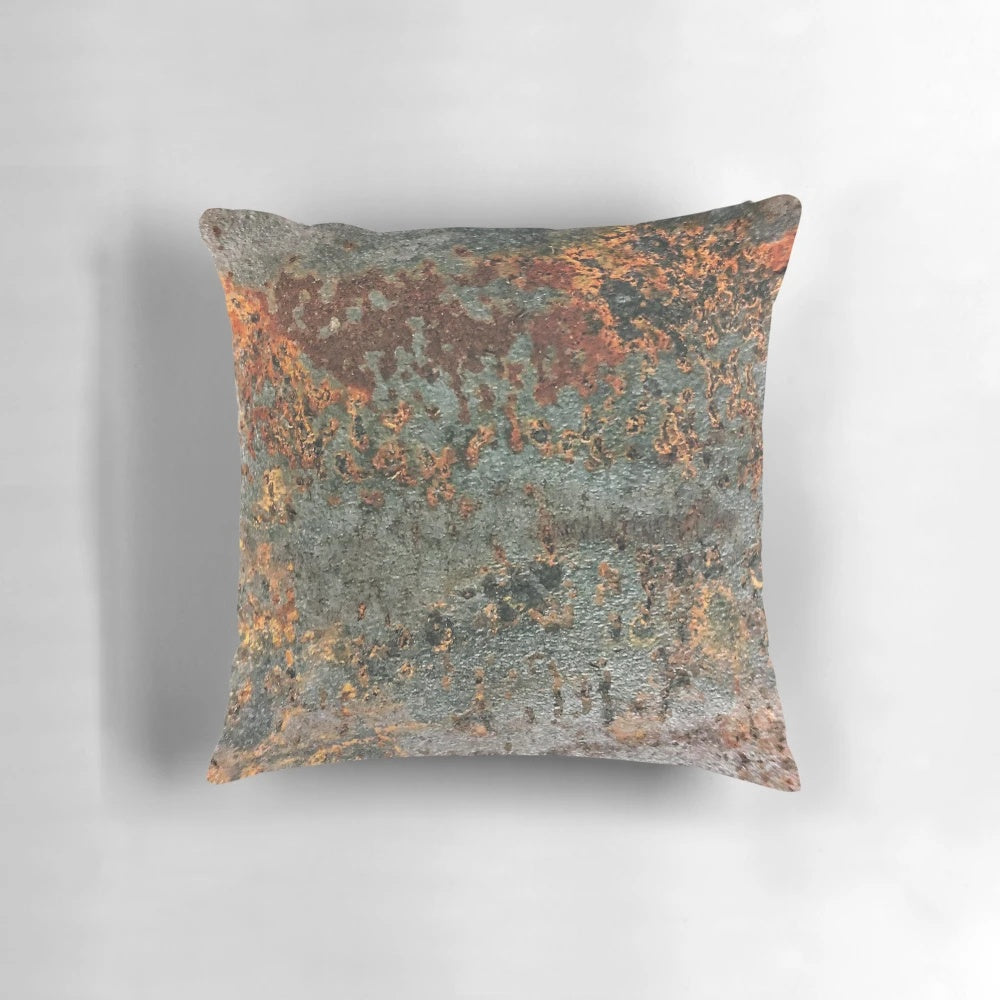 A rusty, metallic pillow with a textured, grungy appearance, perfect for industrial-style home decor.