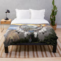 Plush blanket with wolf, bear, and dreamcatcher design in a rustic nature setting