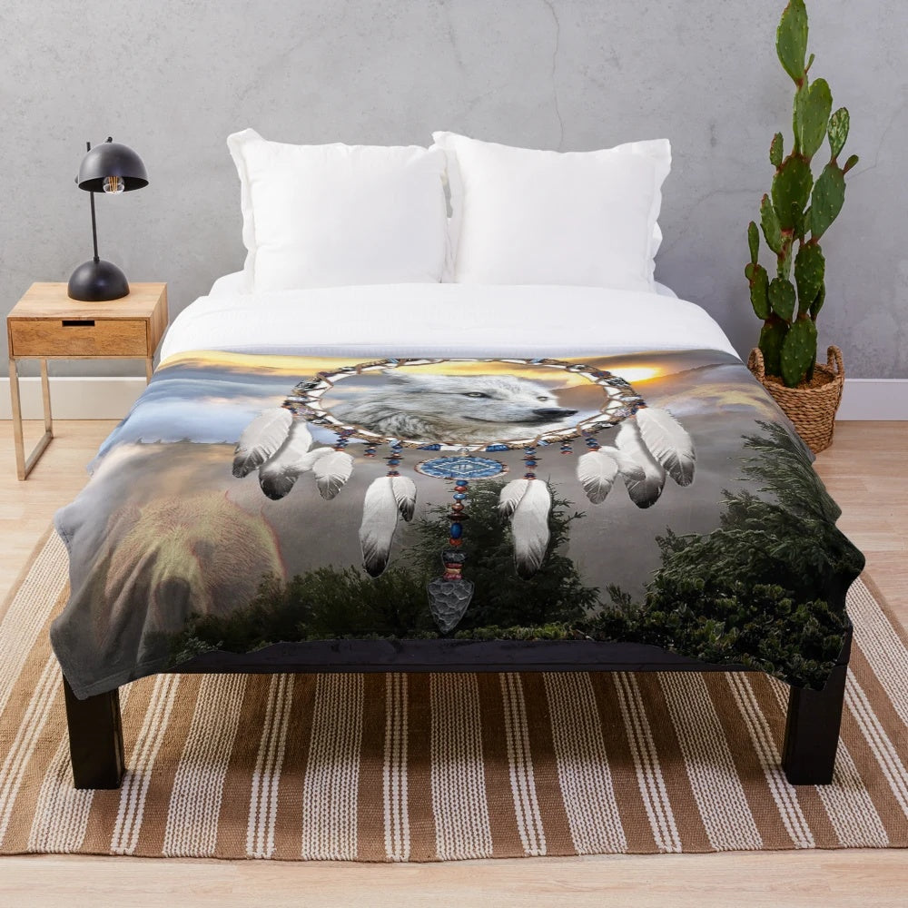 Plush blanket with wolf, bear, and dreamcatcher design in a rustic nature setting