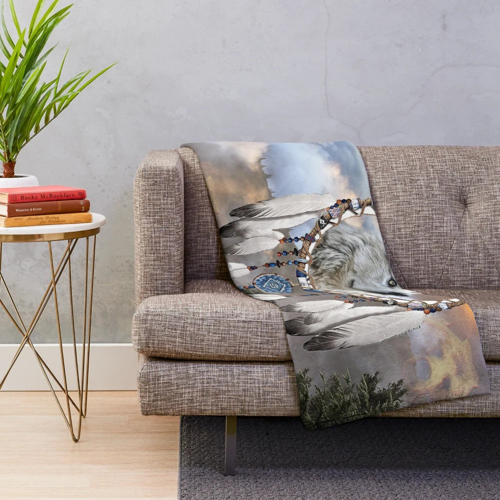 Plush blanket with wolf, bear, and dreamcatcher design in a rustic nature setting