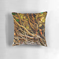 Closeup photo of a decorative pillow with a tangled vine design on a stone background
