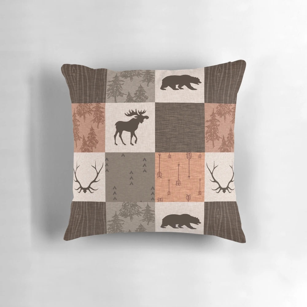 Rustic patchwork pillow in shades of brown, orange, and green featuring a woodland and wildlife design.