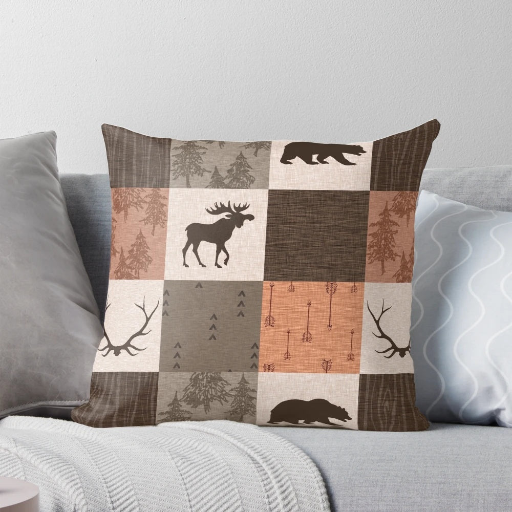 Rustic patchwork pillow in shades of brown, orange, and green featuring a woodland and wildlife design.