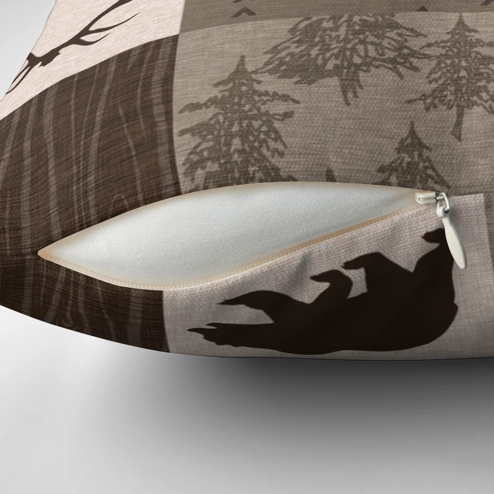 Rustic patchwork pillow in shades of brown, orange, and green featuring a woodland and wildlife design.