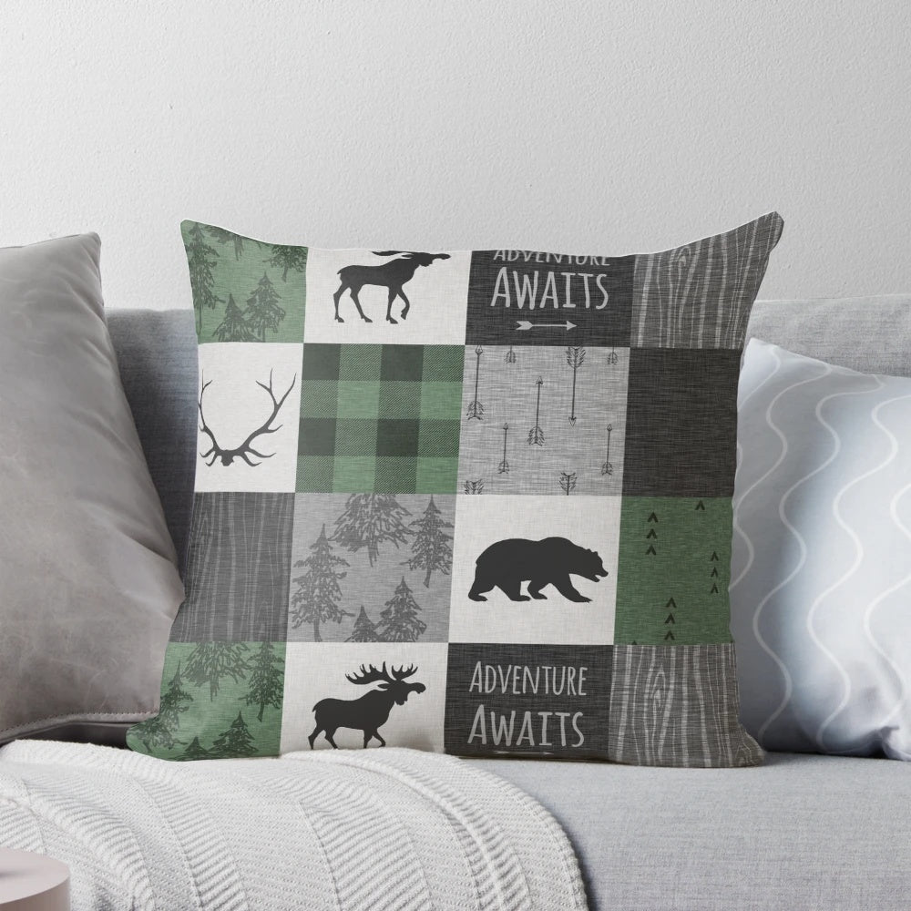 Rustic woodland patchwork throw pillow in shades of gray and green, featuring deer, moose, and other woodland elements.