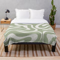 Sage green and white plush blanket featuring an abstract swirl pattern