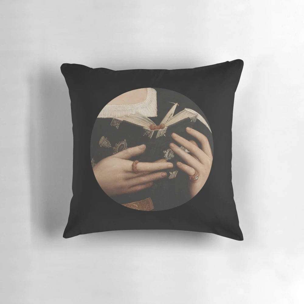 A decorative pillow featuring a renaissance-style painting of a saint holding a book
