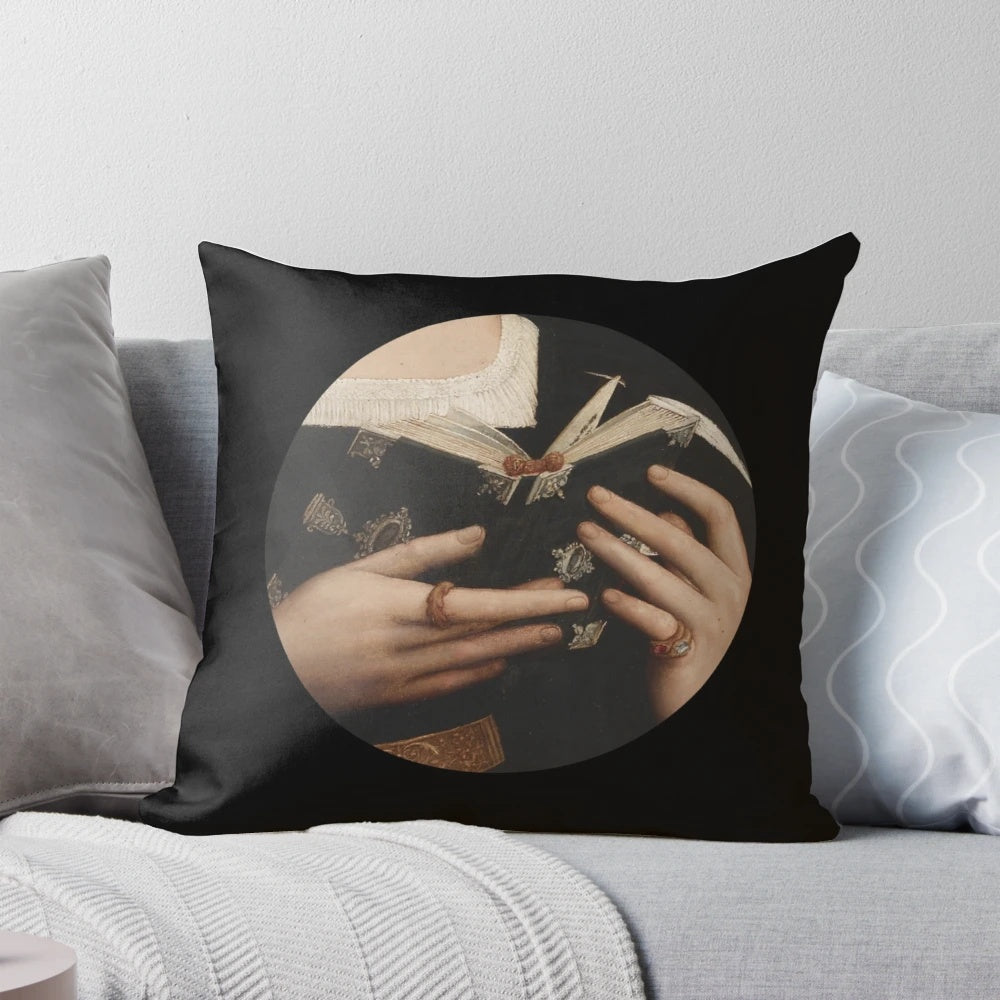 A decorative pillow featuring a renaissance-style painting of a saint holding a book