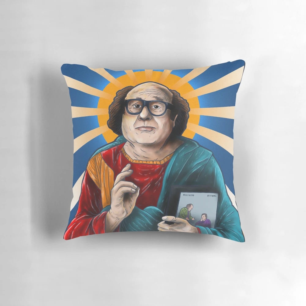 An image of a decorative pillow featuring the iconic actor Danny DeVito, depicted as a saintly figure.