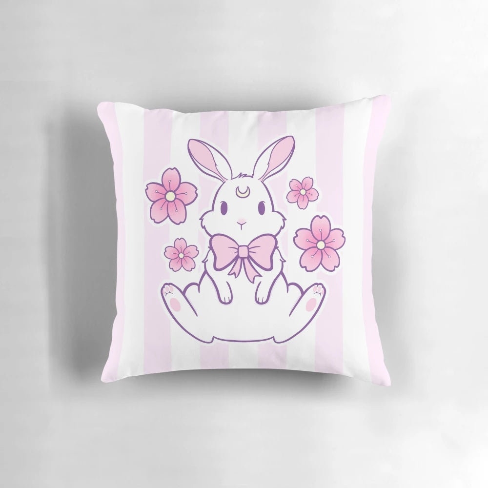 A pastel pink and white bunny pillow with cherry blossom petals, creating a magical and whimsical design.