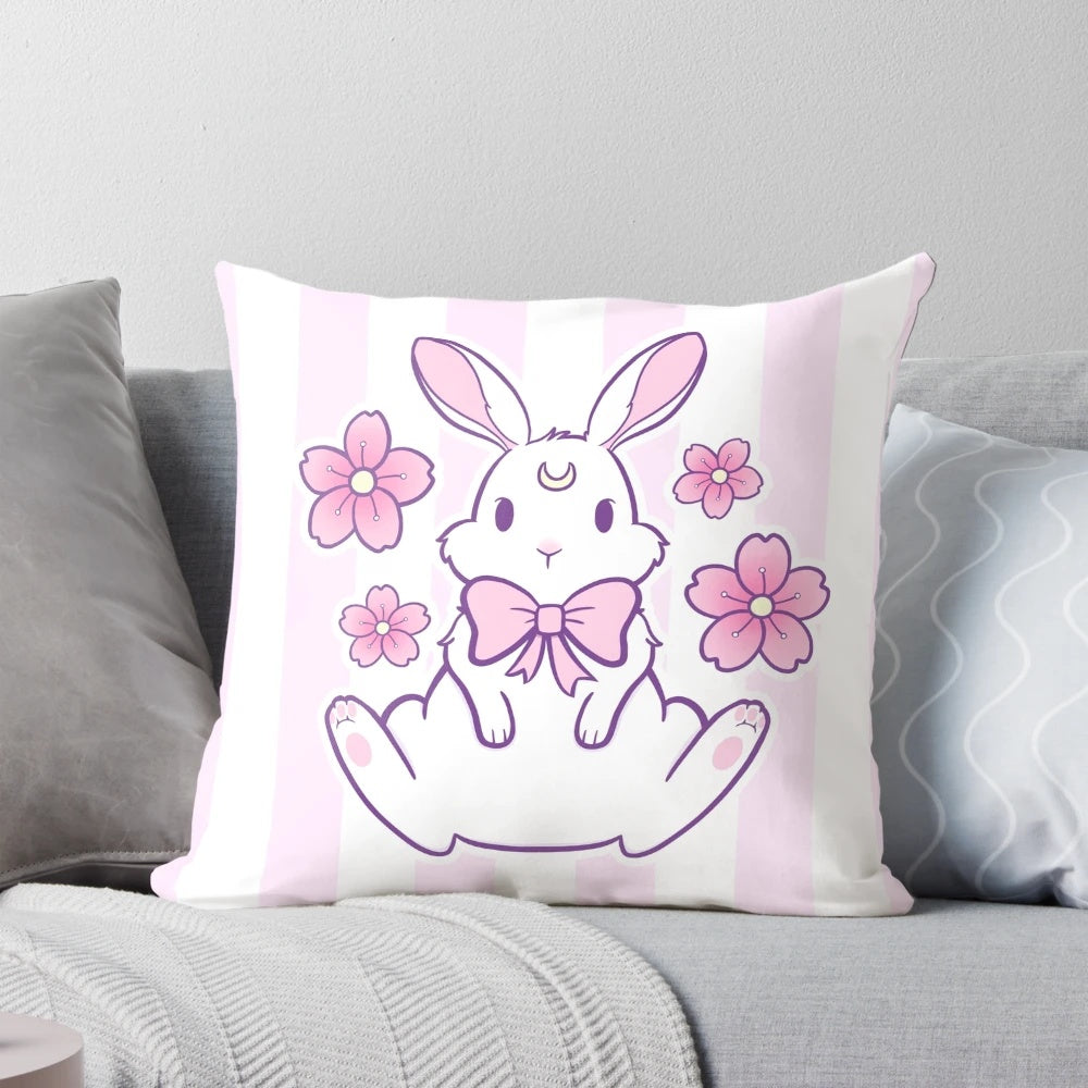 A pastel pink and white bunny pillow with cherry blossom petals, creating a magical and whimsical design.