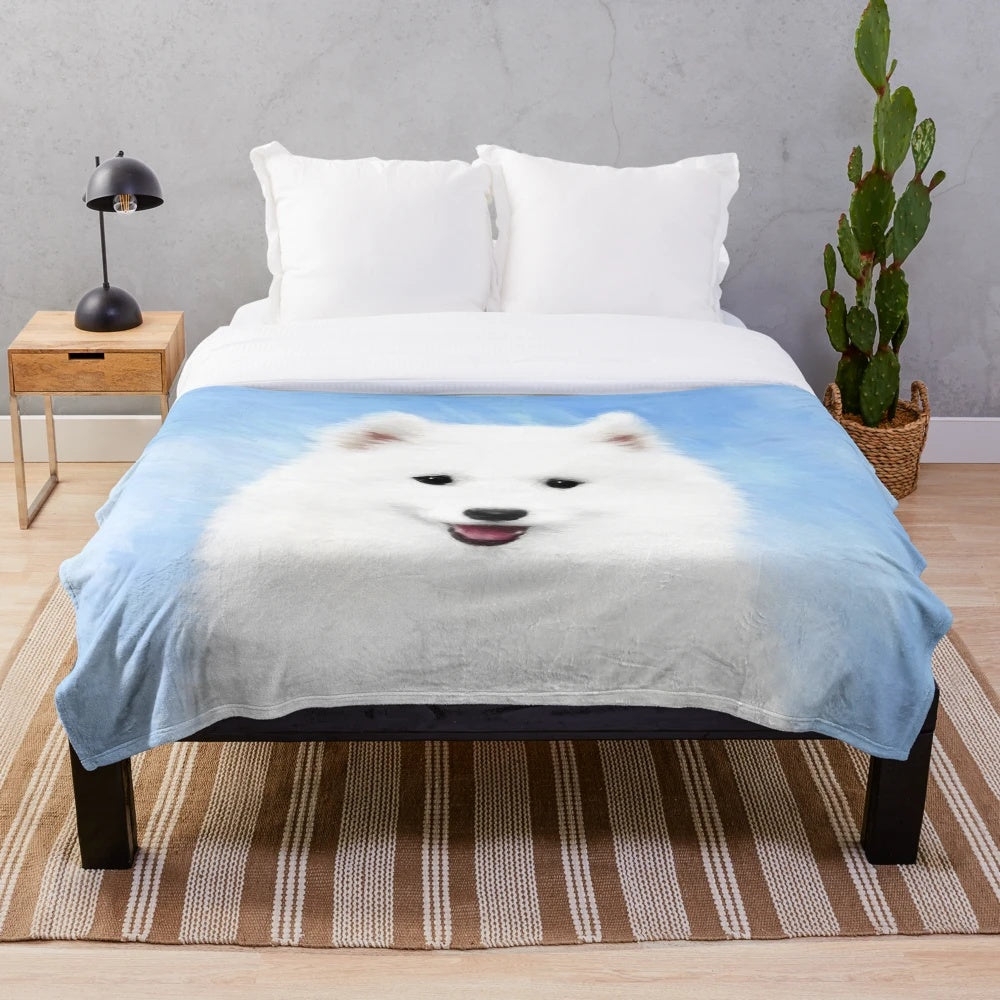 Samoyed puppy on a plush, white blanket